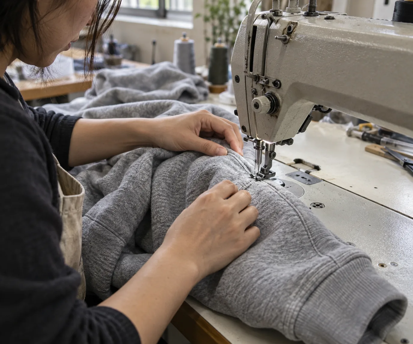 Sample machinist sewing a sweatshirt sleeve for a size evaluation
