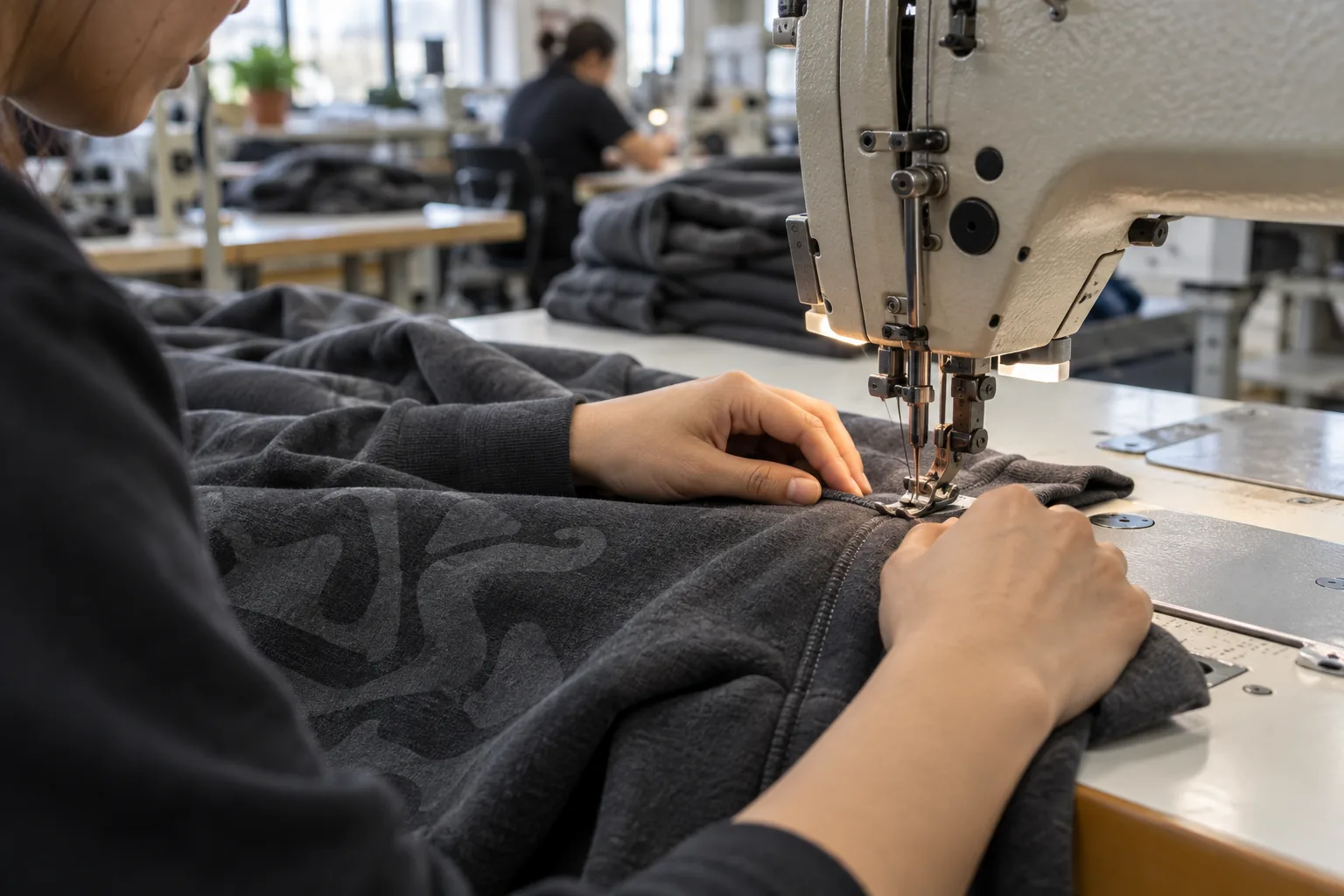 Sewing operator assembling a hoodie panel with an approved tonal print