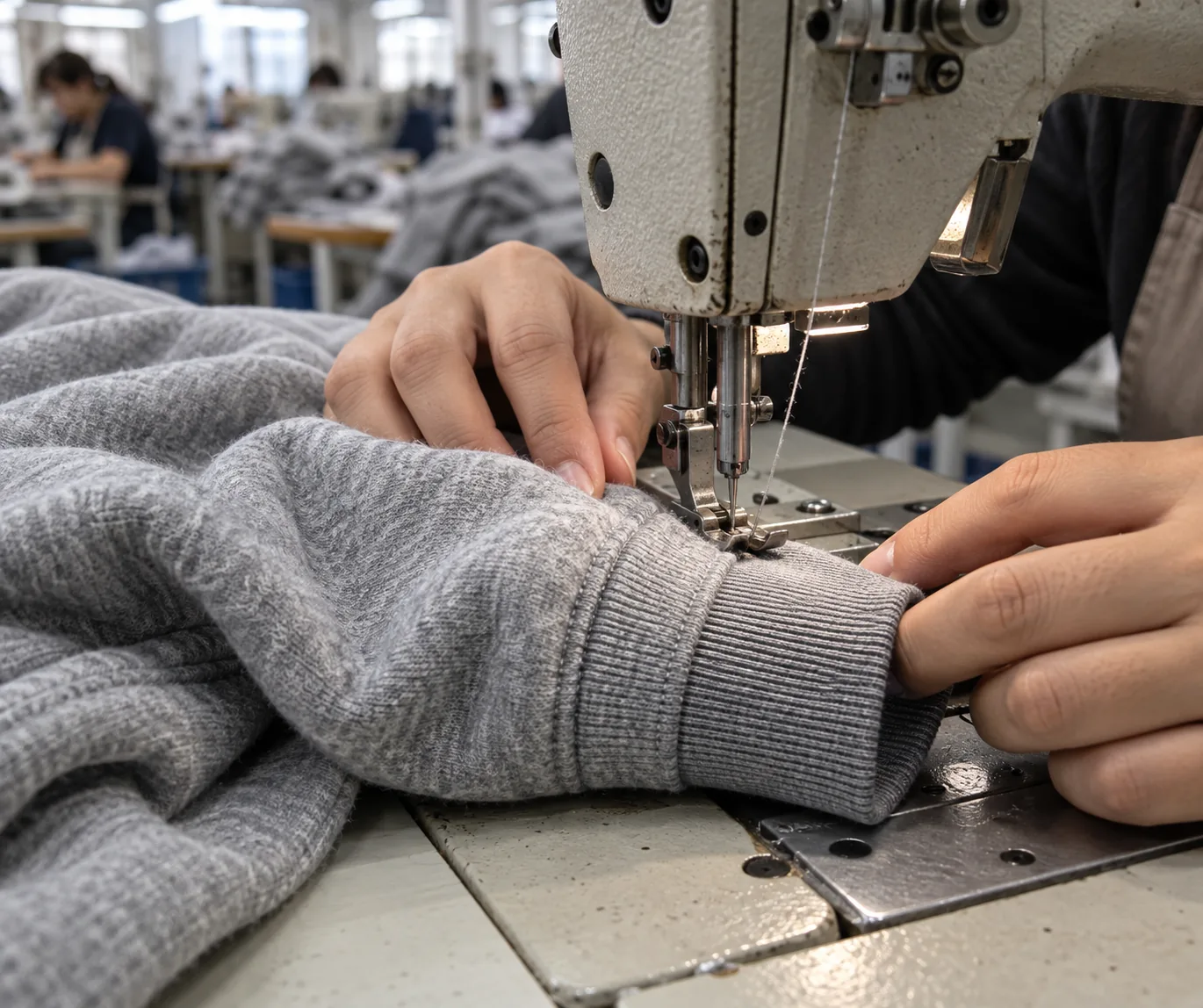 Operator attaching a rib cuff to a heavyweight sweatshirt sleeve
