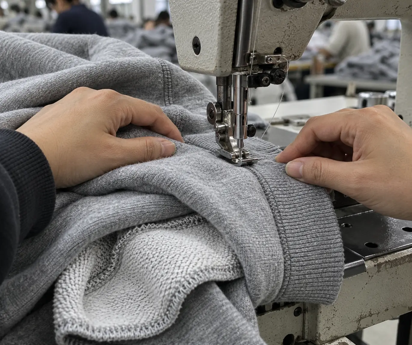 An operator sewing a bulky rib and body seam on a heavyweight sweatshirt